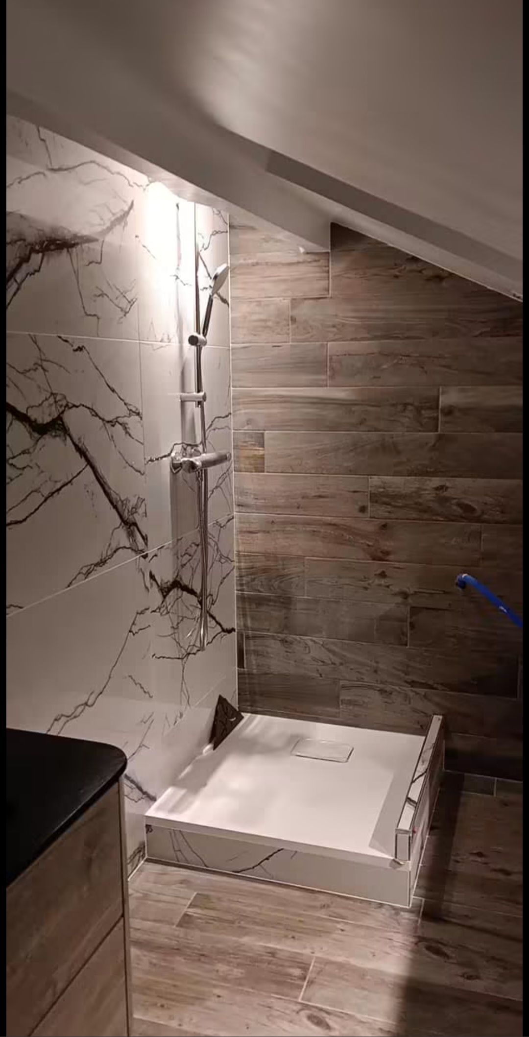 Douche avec revêtements effet marbre et bois, photo fournie pour la maquette